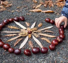 a child is playing with some beads in the shape of a star on the ground