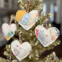 three heart shaped ornaments hanging from a christmas tree