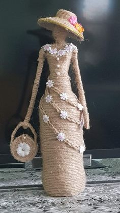 the doll is wearing a straw hat and carrying a basket with flowers on it's head