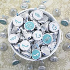 a white bowl filled with lots of silver and blue candies on top of a table