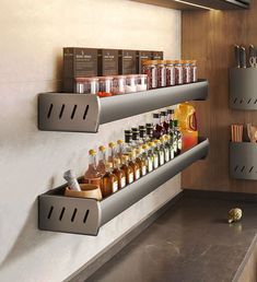 two metal shelves filled with liquor bottles on top of a counter next to a wall