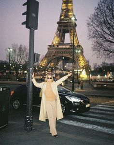 a woman standing next to a pole with the eiffel tower in the background