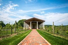 a brick walkway leading to a building in the middle of a field