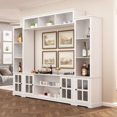 a white entertainment center with glass doors and shelves on the wall in a living room