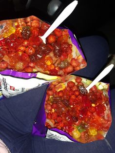 two bags filled with food sitting on top of a person's lap in front of the camera