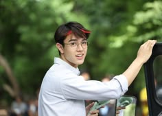 a young man is holding the door handle on a car