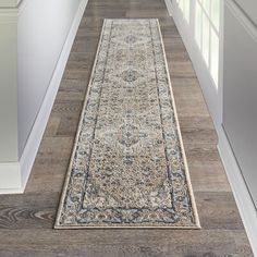 a long rug is on the floor in front of an open door with white trim