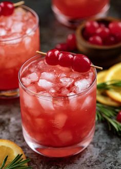 two glasses filled with ice and cherries