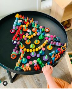 a child is playing with toys on the table