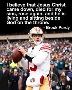 a man holding a football on top of a field with a bible verse in the background