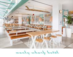 an empty restaurant with tables and stools in the foreground, several lights hanging from the ceiling