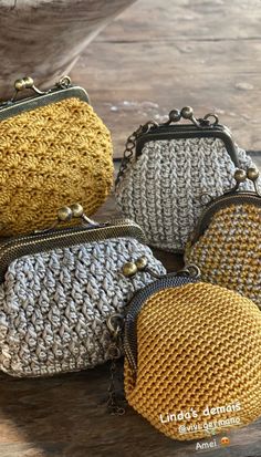 four crocheted purses sitting on top of a wooden table