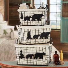 three baskets with bear silhouettes on them sitting on a table in front of a couch