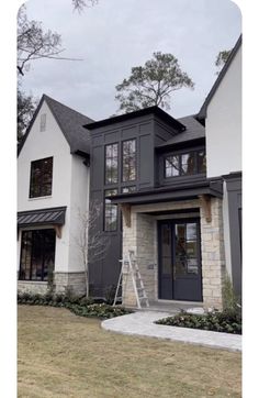 a house that has been painted black and white with some windows on the front door