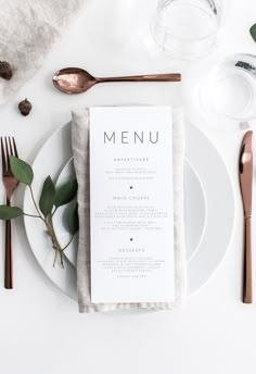 a white plate topped with a menu next to silverware and utensils on top of a table