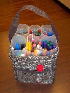 an organized storage container with markers and pencils in it on a wooden table top