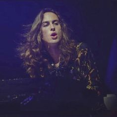 a woman with long hair sitting in front of a keyboard