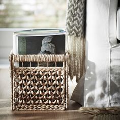 a wicker basket with books in it on the floor