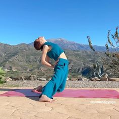 a woman is doing yoga in the mountains