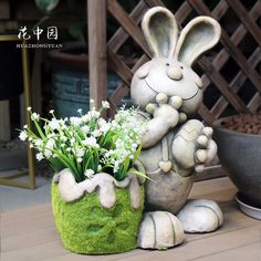 a statue of a bunny holding a potted plant