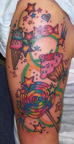 a colorful tattoo on the arm of a woman with candy and lollipops