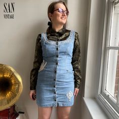 "FREE UK postage * Dispatch within 24h (excl. late Sat/early Sun orders)  A vintage denim dress with a difference! Stand out from the crowd in this light denim mini dress with unique crochet details 💃 Comes in plastic free, recycled packaging ♻️ * The model is 5'7\" and wears size UK10-12  * Shoulders - 16\"  * Bust -18.5\"  * Top to bottom length - 33\"  * Fitted  * Scoop neck  * Thick strap  * Front pockets  * Unique white crochet details  * Front press stud fastening  * 100% cotton  Please k Vintage Cotton Mini Dress, Vintage Cotton Mini Dress For Spring, Vintage Blue Cotton Mini Dress, Vintage Blue Sleeveless Denim Dress, Vintage Light Wash Denim Dress, Vintage Denim Blue Knee-length Dress, Vintage Knee-length Denim Dress For Summer, Vintage Knee-length Denim Blue Dress, Vintage Cotton Mini Dress With Buttons