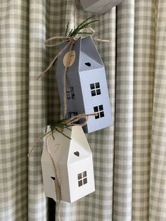 two small houses are hanging on the curtain rod