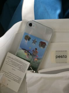 a cell phone case sitting on top of a white bag next to a tag with the name pesto