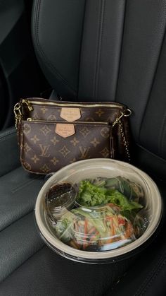 a purse sitting on the back seat of a car next to a plate of food