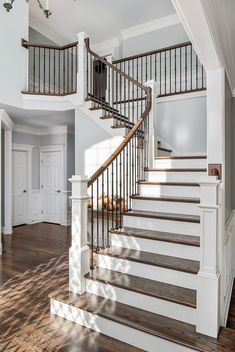 a staircase in a house with white walls and wood floors