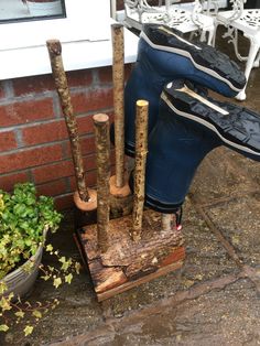 there are several different types of wooden poles in the ground next to a potted plant