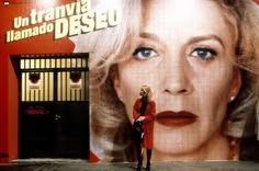 two women standing in front of a movie poster