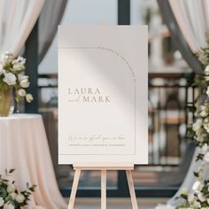 an easel with a sign that says, laurel and mark on it in front of flowers