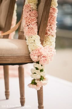 a chair decorated with pink and white flowers on the back of it's seat