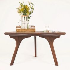 a wooden table topped with vases and flowers on top of it's legs