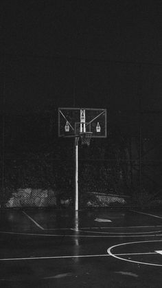 an empty basketball court in the dark with no people on it at night or day