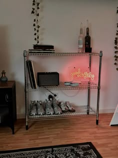 there is a shelf with shoes on it in the living room next to a rug