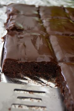 a close up of a piece of chocolate cake on a pan with a fork in it