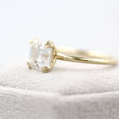 a close up of a ring with a diamond in it on a white cloth background