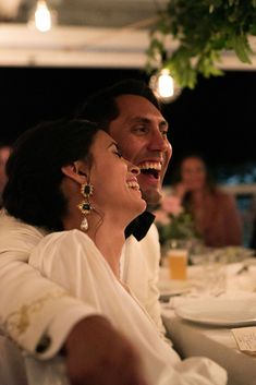 a man and woman sitting at a table laughing