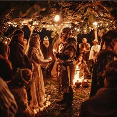 a group of people standing around each other with candles in their hands and lights on the ground