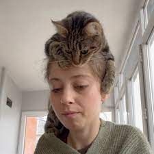 a woman with a cat on her head