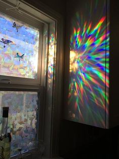 the sun is shining through two windows with colorful light coming in from one window pane