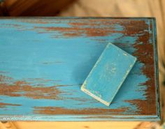 an old blue box with a small book on it's lid sitting on a table