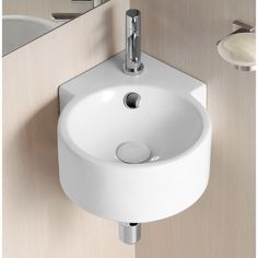 a white bathroom sink sitting on top of a counter next to a wall mounted faucet