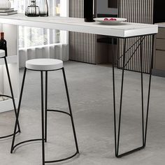 two bar stools sitting next to each other in front of a counter