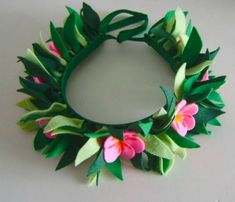 a green wreath with pink flowers and leaves