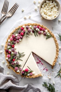 a cheesecake with cranberry sauce and sprinkles is shown on a white surface