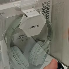 a person is holding a pair of headphones in their hand while they are inside the box