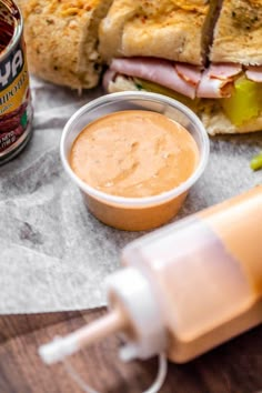 a close up of a sandwich on a table with condiments next to it